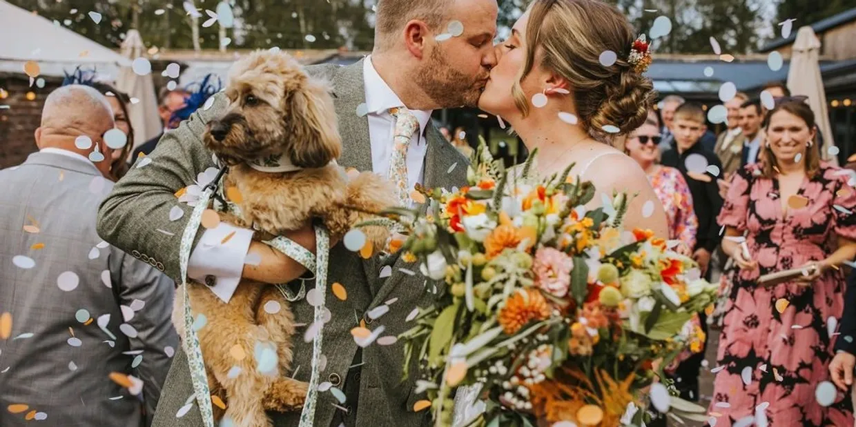 Wedding couple kissing with dog