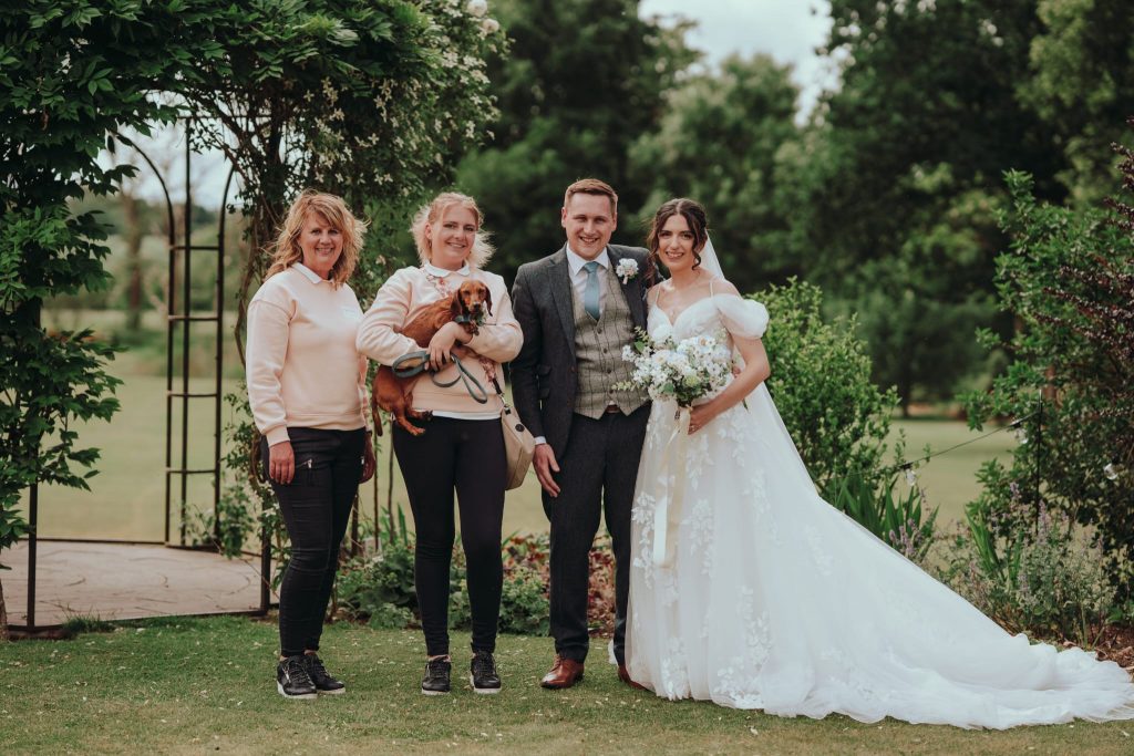 Wedding couple celebrating with their dog Beryl during a Waggy Wedding ceremony in Shropshire, UK, 2025