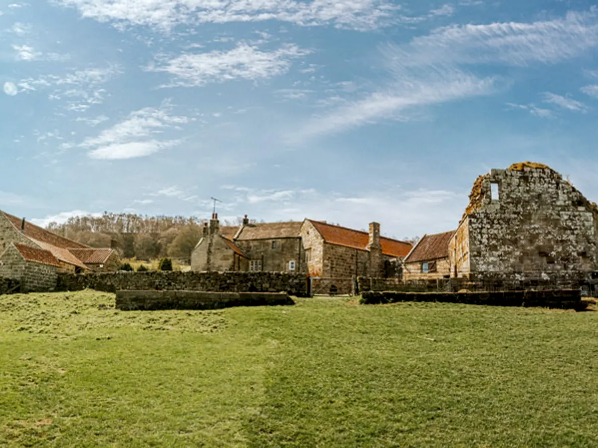 Exterior view of Danby Castle wedding venue showing stone ruins, farm buildings and open grounds in North Yorkshire